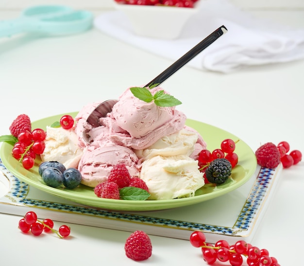 Boules de crème glacée à la vanille et à la framboise sur une plaque verte ronde