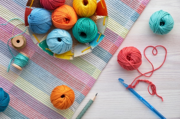 Boules de crochet et de laine, vue de dessus sur bois clair