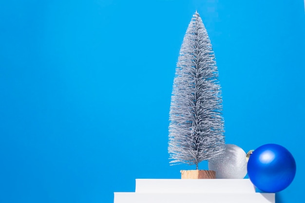 Boules décoratives de sapin de Noël sur un podium blanc sur fond bleu