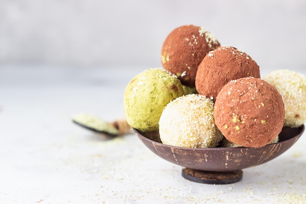 Boules d'énergie crue avec de la poudre de thé matcha, de la poudre de cacao et des flocons de noix de coco