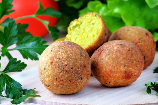 Boules de Falafel sur une planche à découper légère. Fast-food végétarien et végétalien du Moyen-Orient.