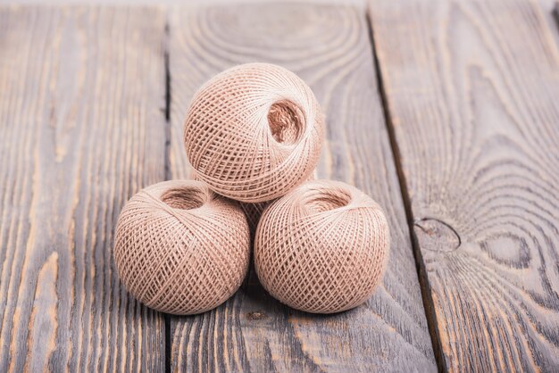 Boules de fil à tricoter sur un espace en bois.