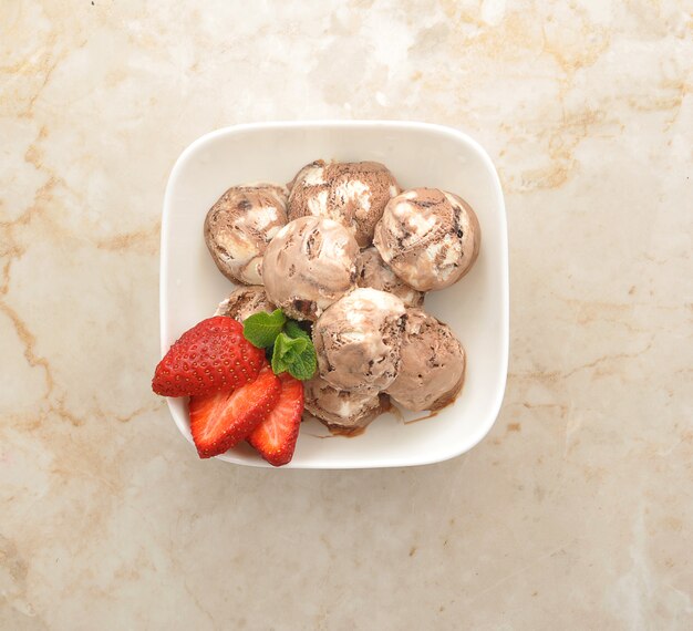 Boules de glace au chocolat avec fraises dans une assiette blanche