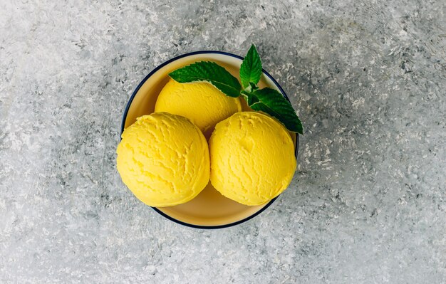 Boules de glace au citron dans un bol sur fond de pierre