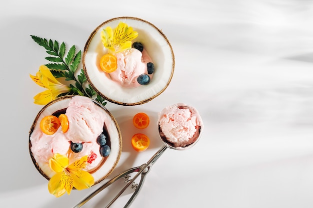 Boules de glace décoration fleurs en moitiés de noix de coco. Concept tropical d'été.