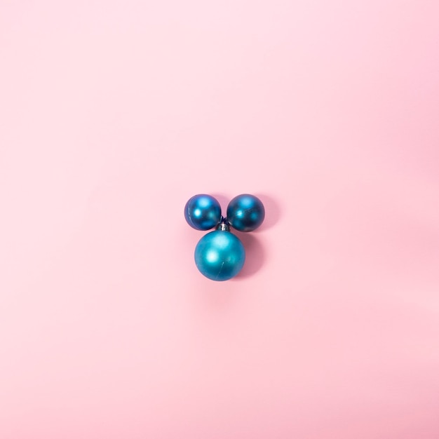 Boules de jouets de Noël bleu sur fond rose Fond minimaliste