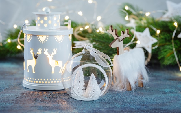 boules et jouets en verre blanc, décoration en bois, lampe sur pied, cerf en bois et poches de poche