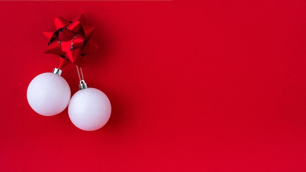 Boules de Noël blanches sur fond rouge. Bannière lumineuse du nouvel an avec un espace pour le texte