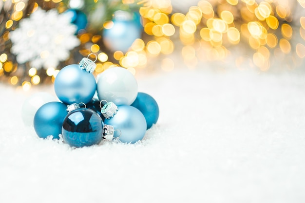 Boules de Noël bleu portant sur la neige sur le fond de l'arbre de Noël