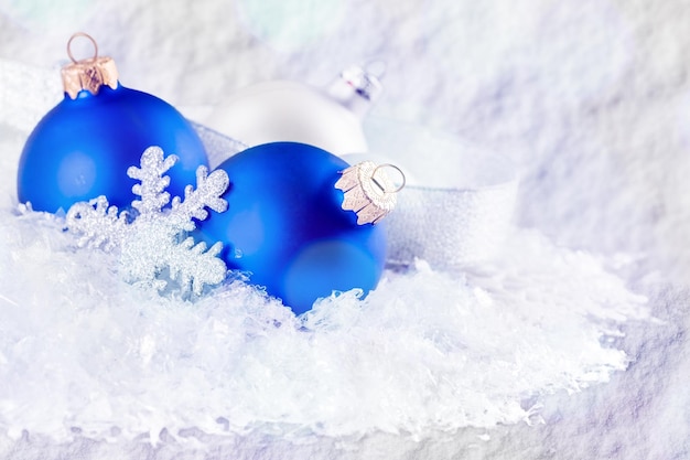 Des boules de Noël bleues sur fond de flocons de neige