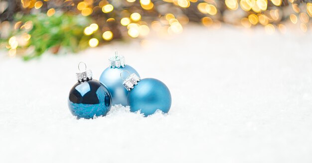 Boules de Noël bleues portant sur la neige