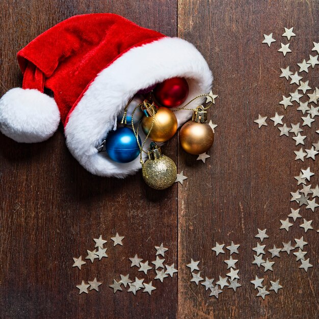 Boules de Noël et bonnet de Noel sur fond de bois Nouvel An