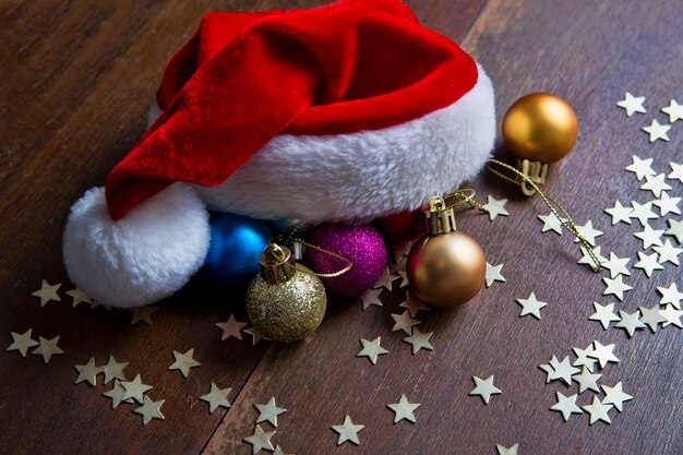 Boules de Noël et bonnet de Noel sur fond de bois Nouvel An