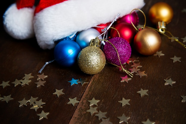 Boules de Noël et bonnet de Noel sur fond de bois Nouvel An