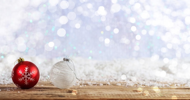 Boules de Noël sur un bureau en bois fond bokeh enneigé