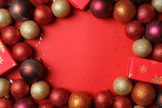 Boules de Noël et cadeaux sur table rouge