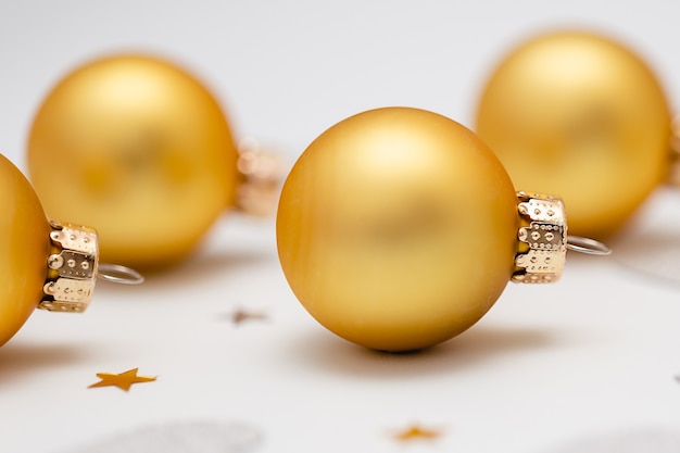 Boules de Noël, décorations dorées sur fond blanc.