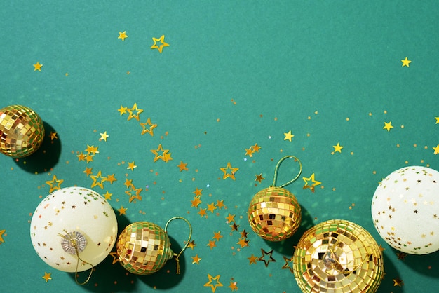 boules de Noël dorées et blanches avec des étoiles brillantes sur fond vert