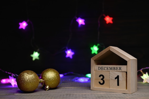 boules de Noël dorées, cubes en bois avec les numéros 31 décembre avec une guirlande multicolore