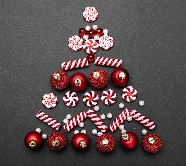 Photo boules de noël en forme d'arbre sur la vue de dessus de fond noir