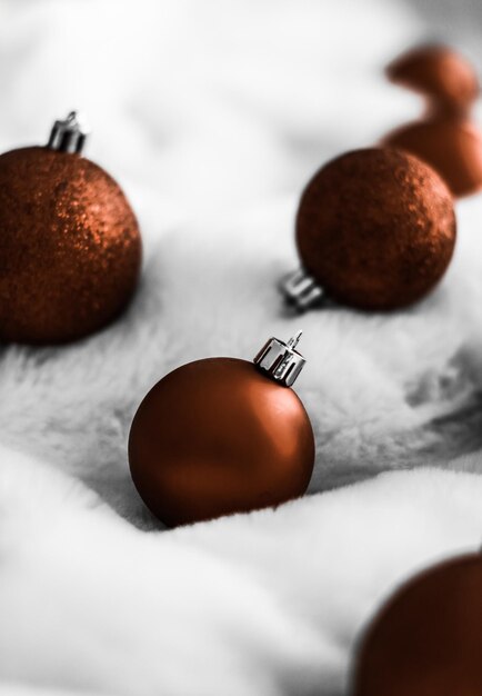 Boules de Noël marron chocolat sur fond de fourrure blanche et moelleuse arrière-plan de conception de vacances d'hiver de luxe