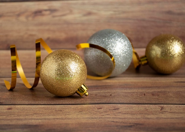 Boules de Noël or et argent et guirlande multicolore sur un fond de Noël en bois Copyspace