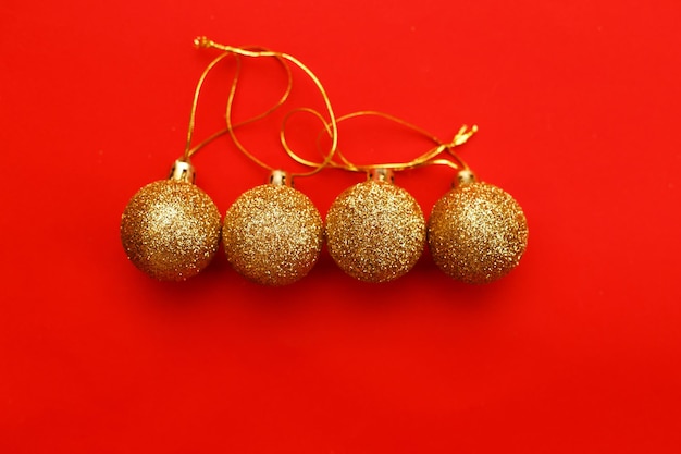 Boules de Noël or sur fond rouge.