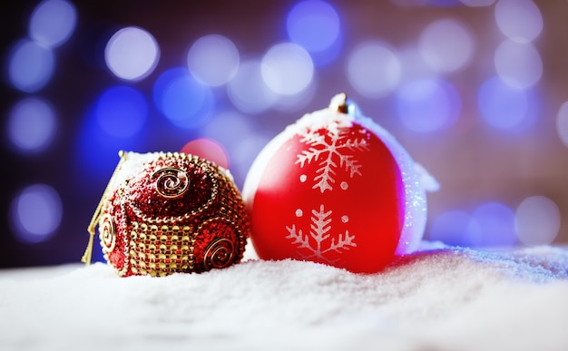 Boules de Noël ornées dans la neige avec rétroéclairage bleu.