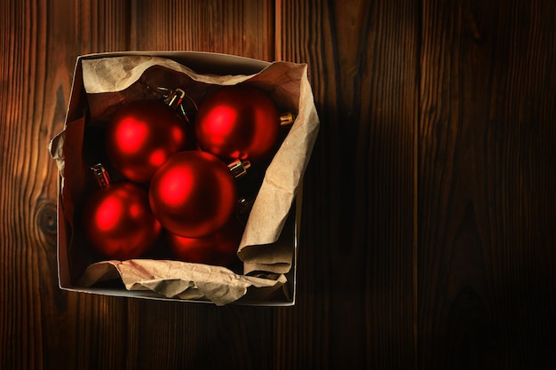 Boules de Noël rouges dans une boîte sur une table en bois