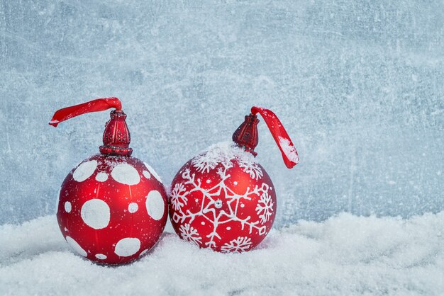 Boules de Noël rouges dans la neige. Fond de Noël fond