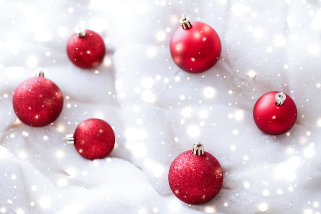 Boules de Noël rouges sur fourrure moelleuse avec fond de conception de vacances d'hiver de luxe scintillant de neige