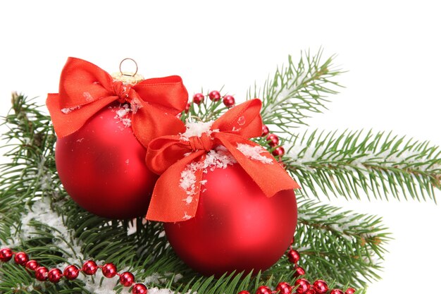 Boules de Noël sur sapin avec de la neige, isolés sur blanc