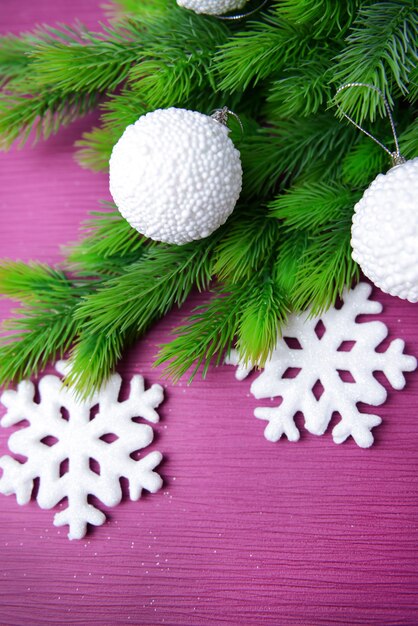 Boules de Noël sur sapin, sur une surface de couleur