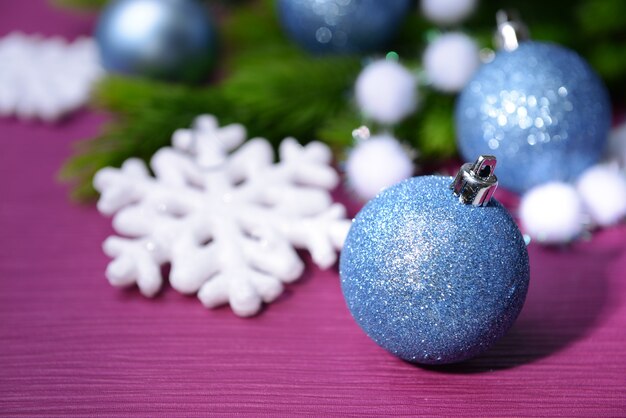 Boules de Noël sur sapin, sur une surface de couleur