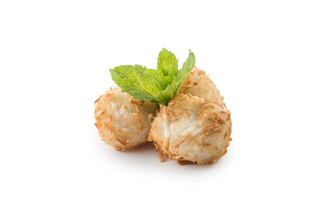 Boules de noix de coco sucrées frites traditionnelles japonaises avec des feuilles de menthe isolées sur fond blanc.