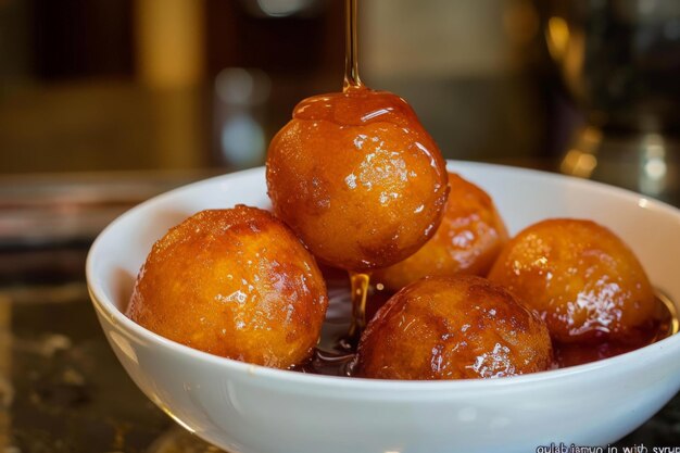 Les boules d'or de gulab jamun brillent avec du sirop prêt à être savouré