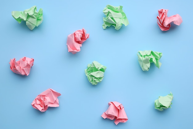 Boules de papier froissé multicolore sur fond bleu.