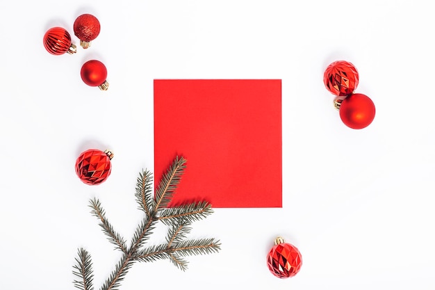 Boules rouges décoratives, brindilles d'épinette et un rouge vierge sur fond blanc. Vue de dessus, mise à plat.