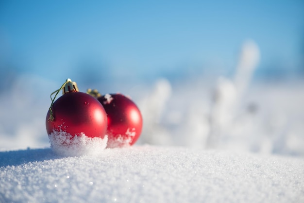 boules rouges de noël avec de longues ombres dans la neige fraîche sur une belle journée d'hiver ensoleillée