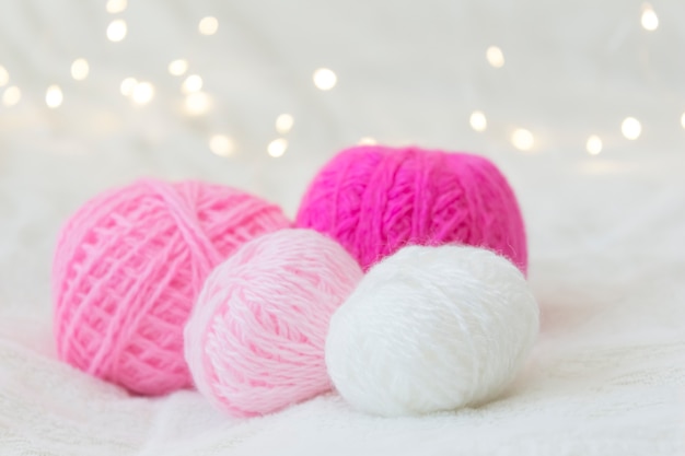 Boules de tricot rose se trouvent sur un fond jaune bokeh