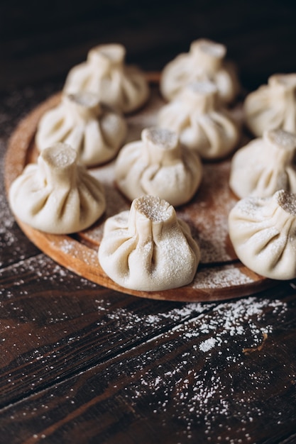 Boulette maison géorgienne ou khinkali sur planche de bois à découper.