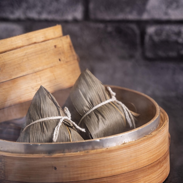 Boulette de riz zongzi Boulette de riz chinois zongzi sur fond de brique noire concept de table en ardoise de la nourriture traditionnelle du Festival des bateaux-dragons en gros plan