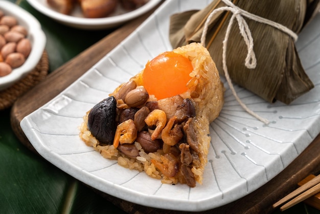 Boulette de riz Zongzi pour Dragon Boat Festival sur fond de feuille verte avec ingrédient