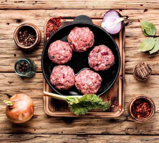 Boulette de viande crue sur fond de bois