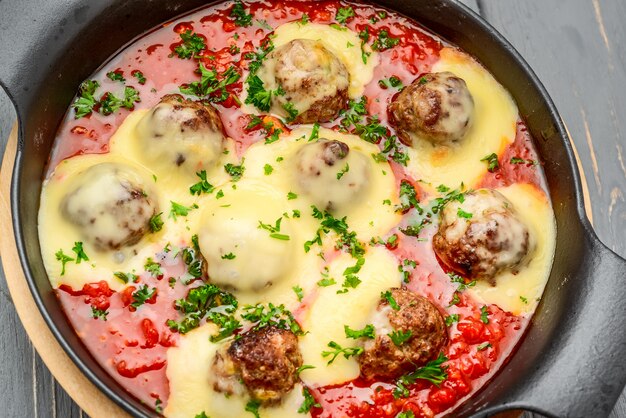 Boulettes de boeuf au parmesan et sauce tomate dans une poêle