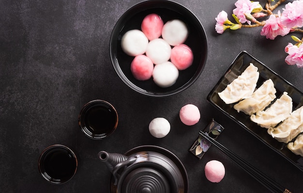 Boulettes de boulettes Tang Yuansweet une cuisine traditionnelle pour le solstice d'hiver de Midautumn Dongzhi et le nouvel an chinois avec fleur de prunier et thé sur fond sombre