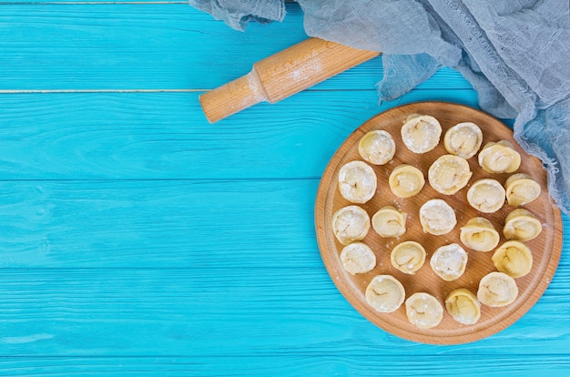 Boulettes crues maison, pelmeni, sur bois.