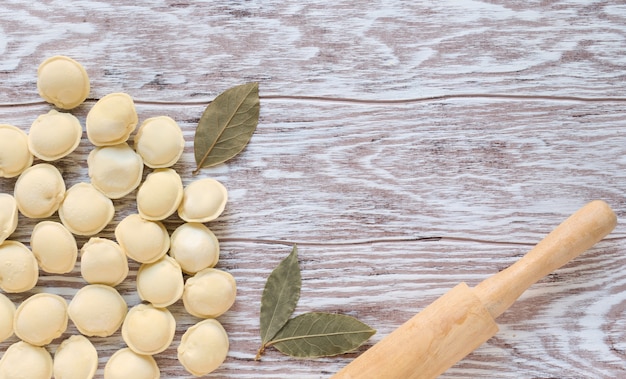 Boulettes crues et rouleau à pâtisserie sur un fond en bois avec espace de copie