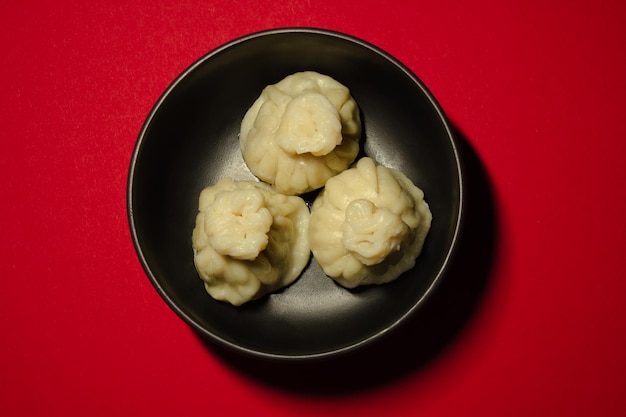 Boulettes cuites à la vapeur traditionnelles khinkali sur le fond rouge