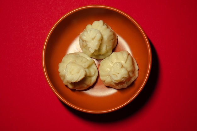 Boulettes cuites à la vapeur traditionnelles khinkali sur le fond rouge